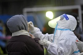 Nhân viên y tế lấy mẫu xét nghiệm COVID-19 cho người dân tại Thiên Tân, Trung Quốc ngày 20/1/2022. (Ảnh: THX/TTXVN)