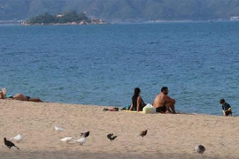 Du khách nước ngoài tắm nắng trên bãi biển Nha Trang. (Ảnh: Tiên Minh/TTXVN)
