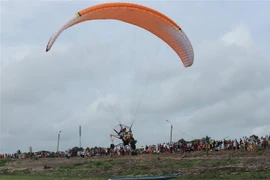 Du khách trải nghiệm dù lượn tại bãi bồi, hồ Dầu Tiếng Tây Ninh. (Ảnh: Thanh Tân/TTXVN)