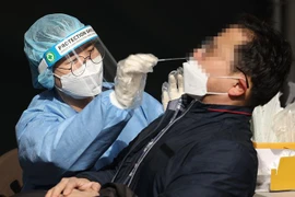 Nhân viên y tế lấy mẫu xét nghiệm COVID-19 cho người dân tại Seoul, Hàn Quốc. (Ảnh: Yonhap/TTXVN)