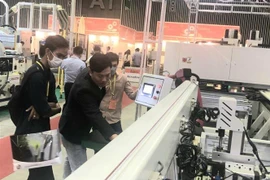 Khách tham quan tìm hiểu về thiết bị chế biến gỗ tại VietnamWood 2022 và Funitec 2022. (Ảnh: Xuân Anh/TTXVN)
