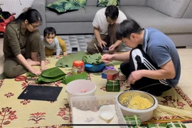 Một gia đình Việt kiều ở Vitré quây quần gói bánh chưng. (Ảnh Thu Hà/TTXVN)