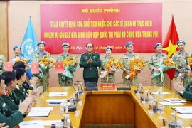 Thượng tướng Phùng Sĩ Tấn trao quyết định cho 4 sỹ quan và chúc mừng 4 sỹ quan đã hoàn thành nhiệm vụ ngày 16/12. (Ảnh: Trọng Đức/TTXVN)