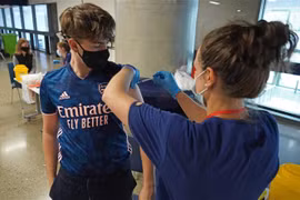 Tiêm vaccine ngừa COVID-19 cho trẻ vị thành niên tại London, Anh ngày 20/6/2021. (Ảnh: AFP/TTXVN)