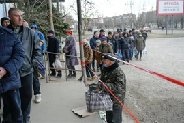 Người dân xếp hàng chờ nhận lượng thực cứu trợ tại Mykolaiv, Ukraine ngày 14/3/2022. (Ảnh: AFP/TTXVN)
