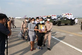 Người thân của các thủy thủ thiệt mạng trong vụ chìm tàu HTMS Sukhothai mang ảnh người thân tại tỉnh Rayong, Thái Lan, ngày 22/12/2022. (Ảnh: AFP/TTXVN)