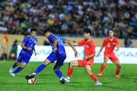 Weerathep Pomphun (18) của U23 Thái Lan nỗ lực đi bóng trước sự truy cản của cầu thủ U23 Singapore. (Ảnh: Tuấn Anh/TTXVN)