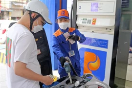 Người dân mua xăng dầu sau khi điều chỉnh giá mới tại một cửa hàng của Petrolimex. (Ảnh: Trần Việt/TTXVN)