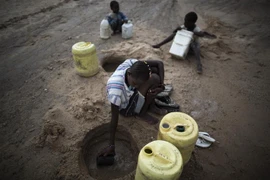 Người dân cố gắng múc nước từ đáy sông khô cạn ở Turkana, Kenya. (Ảnh: AFP/TTXVN)