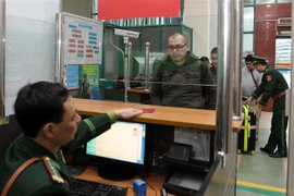 Cán bộ chiến sỹ Đồn Biên phòng cửa khẩu Quốc tế Lào Cai làm thủ tục nhập cảnh cho đoàn du khách nước ngoài vào Việt Nam. (Ảnh: Quốc Khánh/TTXVN)