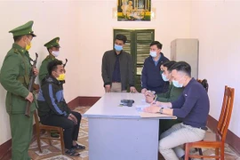 Đối tượng Và A Xế và tang vật tại cơ quan điều tra. (Ảnh: TTXVN phát)