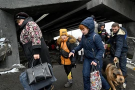 Người dân Ukraine sơ tán khỏi thành phố Irpin, phía Tây Bắc thủ đô Kiev ngày 8/3/2022. (Ảnh: AFP/TTXVN)