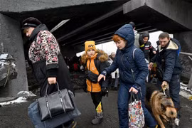 Người dân Ukraine sơ tán khỏi thành phố Irpin, phía Tây Bắc thủ đô Kiev ngày 8/3/2022. (Ảnh: AFP/TTXVN)