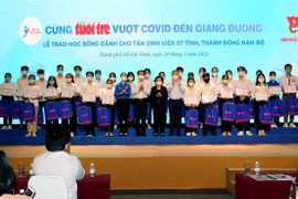 Đại diện Ban tổ chức với các tân sinh viên, học sinh Thành phố Hồ Chí Minh và các tỉnh miền Đông Nam bộ nhận học bổng “Tiếp sức đến trường” năm học 2021-2022. (Ảnh: Thanh Vũ/TTXVN)
