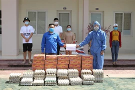 Đại diện Đại sứ quán Việt Nam tại Lào trao quà cho sinh viên Việt Nam đang học tập tại Đại học Quốc gia Lào gặp khó khăn do dịch bệnh COVID-19. (Ảnh: Thu Phương/TTXVN)