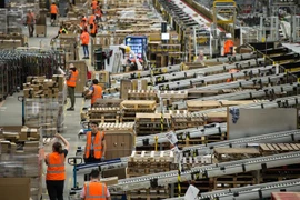 Nhân viên đóng gói hàng hóa cho khách hàng tại một trung tâm dịch vụ của Amazon. (Ảnh: AFP/TTXVN)