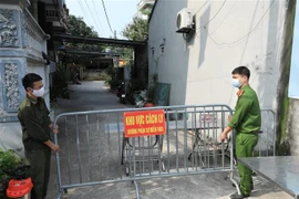 Lực lượng chức năng phong tỏa ngõ 83 đường Dục Nội (Đông Anh, Hà Nội) nơi ở của ca bệnh 2911. (Ảnh: Minh Đức/TTXVN)