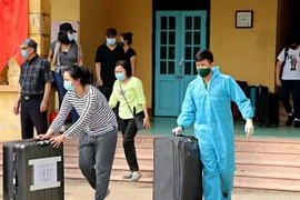 Cán bộ, chiến sỹ giúp công dân chuyển đồ dùng cá nhân sau khi hoàn thành thời gian cách ly tập trung. Ảnh minh họa. (Ảnh: Thanh Hải/TTXVN)