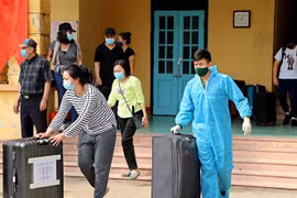Cán bộ, chiến sỹ giúp công dân chuyển đồ dùng cá nhân sau khi hoàn thành thời gian cách ly tập trung. Ảnh minh họa. (Ảnh: Thanh Hải/TTXVN)