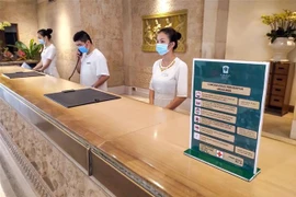 Khu nghỉ mát Furama Resort tăng cường biện pháp phòng chống dịch bằng các bảng khuyến cáo phòng dịch và nhân viên thực hiện đeo khẩu trang khi làm việc. (Ảnh: TTXVN phát)