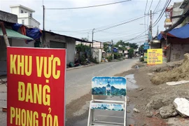 Lực lượng chức năng phong tỏa một đoạn đường TL19 (Khu phố 3B, phường Thạnh Lộc, Quận 12, Thành phố Hồ Chí Minh). (Ảnh: Tiến Lực/TTXVN)