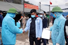 Kiểm tra y tế tại điểm tiếp nhận cách ly tập trung Cửa khẩu Quốc tế Cầu Treo. (Ảnh: Công Tường/TTXVN)