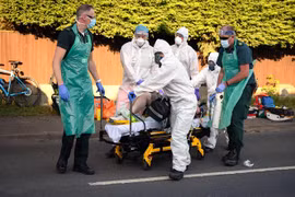 Nhân viên y tế chuyển bệnh nhân mắc COVID-19 ra xe cứu thương tại Botley, Anh. (Ảnh: AFP/TTXVN)