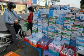 Một quầy hàng ven đường bán khẩu trang và nước sát khuẩn tại Phnom Penh, Campuchia. (Ảnh: AFP/TTXVN)