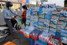 Một quầy hàng ven đường bán khẩu trang và nước sát khuẩn tại Phnom Penh, Campuchia. (Ảnh: AFP/TTXVN)