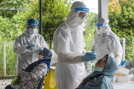 Nhân viên y tế lấy mẫu xét nghiệm COVID-19 cho người dân tại Ampang, gần Kuala Lumpur, Malaysia. (Ảnh: THX/TTXVN)