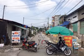 Lực lượng chức năng phong tỏa một đoạn đường TL19 (Khu phố 3B, phường Thạnh Lộc, Quận 12, Thành phố Hồ Chí Minh). (Ảnh: Tiến Lực/TTXVN)