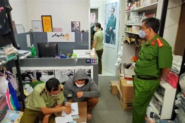 Lực lượng chức năng kiểm tra cửa hàng ở địa chỉ 65A Huỳnh Văn Bánh, quận Phú Nhuận. (Ảnh: Thành Chung/TTXVN)