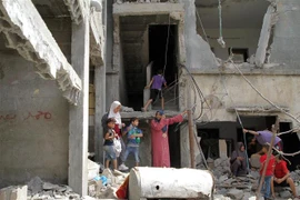Người dân Palestine trở về bên những căn nhà đã bị phá hủy trong các cuộc không kích của máy bay Israel xuống thị trấn Beit Hanoun, Dải Gaza, khi lệnh ngừng bắn có hiệu lực, ngày 21/5. (Ảnh: THX/TTXVN)