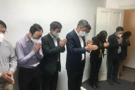 Cán bộ Đại sứ quán Việt Nam tại Đức nghiêng mình trước bàn thờ Bác trong khuôn viên Đại sứ quán. (Ảnh: Mạnh Hùng/Vietnam+)