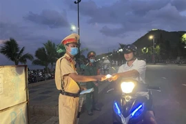 Lực lượng chức năng của thành phố Vũng Tàu ra quân nhắc nhở, phát khẩu trang và xử phạt các trường hợp không đeo khẩu trang nơi công cộng vào sáng 3/5. (Ảnh: Hoàng Nhị/TTXVN)