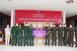 Đại diện Binh đoàn 11, Bộ Quốc phòng Việt Nam (bên trái) trao quà cho Bộ Quốc phòng Lào nhằm hỗ trợ phòng chống dịch COVID-19. (Ảnh: Thu Phương/TTXVN)