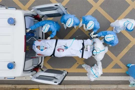 Nhân viên y tế chuyển bệnh nhân COVID-19 tới bệnh viện ở Vũ Hán, tỉnh Hồ Bắc, Trung Quốc. (Ảnh: THX/TTXVN)