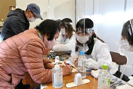 Người dân đăng ký tiêm vaccine ngừa COVID-19 tại Tokyo, Nhật Bản. (Ảnh: AFP/TTXVN)