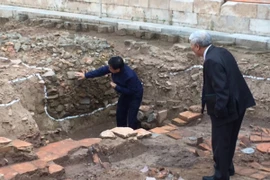 Phó giáo sư-tiến sỹ Tống Trung Tín (trái) giới thiệu về các dấu tích mới phát lộ tại các hố khai quật trong năm 2016. (Ảnh: An Ngọc/Vietnam+)