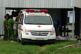 Lực lượng chức năng đưa thi thể nạn nhân ra khỏi hiện trường. (Ảnh: Xuân Triệu/TTXVN)