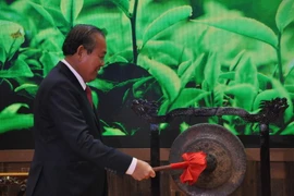 Phó Thủ tướng Thường trực Chính phủ Trương Hòa Bình đánh chiêng tại Lễ khai trương Khu gian hàng quốc gia tại Hội chợ Trung Quốc-ASEAN. (Ảnh : Lê Trung Kiên/TTXVN)