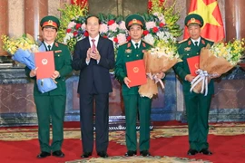 Chủ tịch nước Trần Đại Quang trao Quyết định thăng quân hàm cho ba sỹ quan cao cấp. (Ảnh: Nhan Sáng/TTXVN)