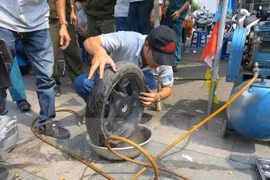 Vá lốp xe bị cán đinh. (Ảnh: Hải Âu/TTXVN)
