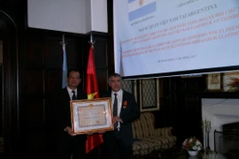 Đại sứ Việt Nam tại Argentina Nguyễn Đình Thao trao Huân chương Hữu nghị của Chủ tịch nước Trần Đại Quang cho ông Claudio Gutierrez, cựu Đại sứ Argentina tại Việt Nam. (Ảnh: Phương Lan/Vietnam+)