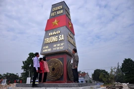 Ông Phan Văn Lài (phải), Chủ tịch Hội Cựu chiến binh xã Bình Dương giới thiệu về công trình cho các em học sinh. (Ảnh: Đỗ Trưởng/TTXVN)