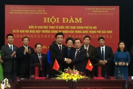 Chủ tịch Ủy ban Mặt trận Tổ quốc Việt Nam thành phố Hà Nội Vũ Hồng Khanh và Chủ tịch Chính hiệp Bắc Kinh Cát Lâm bắt tay giao lưu. (Ảnh: Minh Huệ/TTXVN)