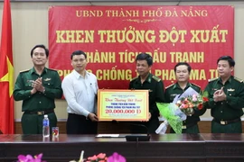 Phó Chủ tịch Ủy ban Nhân dân thành phố Hồ Kỳ Minh (áo trắng) trao thưởng nóng cho cán bộ, chiến sỹ lực lượng phòng chống tội phạm ma túy Bộ đội biên phòng Đà Nẵng. (Ảnh: Trần Lê Lâm/Vietnam+)