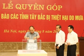 Thủ tướng Nguyễn Xuân Phúc, Phó Thủ tướng Thường trực Trương Hoà Bình, Phó Thủ tướng Vương Đình Huệ ủng hộ đồng bào các tỉnh Tây Bắc bị thiệt hại do mưa lũ. (Ảnh: Thống Nhất/TTXVN)