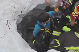 Các nhân viên cứu hộ đưa nạn nhân ra khỏi đống đổ nát của khách sạn Rigopiano ngày 18/1. (Nguồn: EPA/TTXVN)