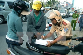 Cảnh sát giao thông xử lý người điều khiển phương tiện vi phạm giao thông. (Ảnh: Bùi Tường/TTXVN)